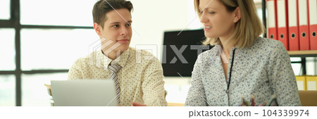 Woman manager teaching trainee how to work on laptop in office 104339974