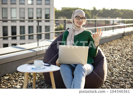Freelancer with laptop daydreaming on office roof terrace Freelancer with laptop daydreaming on office roof terrace 104340361