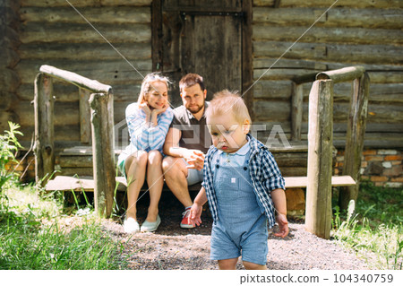 Mom, dad and little son spend time together in the summer outdoors 104340759