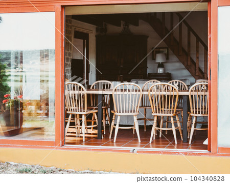 Open room with wooden furniture, large sliding windows Open room with wooden furniture, large sliding windows 104340828