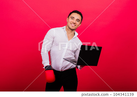 Guy in boxing gloves and formalwear punch computer isolated on red, cyber bullying. Guy in boxing gloves and formalwear punch computer isolated on red, cyber bullying. 104341139