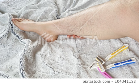 Pink, yellow and blue disposable razors and hairy female legs Pink, yellow and blue disposable razors and hairy female legs 104341158