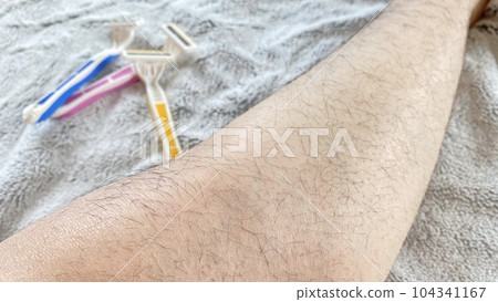 粉色、黃色和藍色一次性剃須刀和毛茸茸的女性腿 104341167