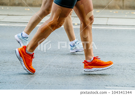 close-up legs couple runners man and woman running marathon race together close-up legs couple runners man and woman running marathon race together 104341344