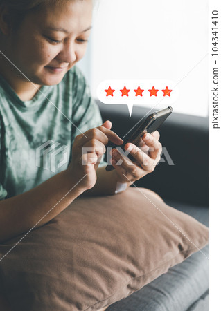 woman use smartphone select on the five star to give satisfaction in service.rating very impressed.Customer service and Satisfaction concept. 104341410