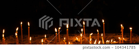 Burning candles in the church on a dark background. The idea of prayer and religion 104341785