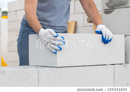 Worker laying gas block on the wall. Worker laying gas block on the wall. 104341834