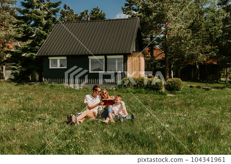 Parents with Child Reading Book Together Outdoors Parents with Child Reading Book Together Outdoors 104341961
