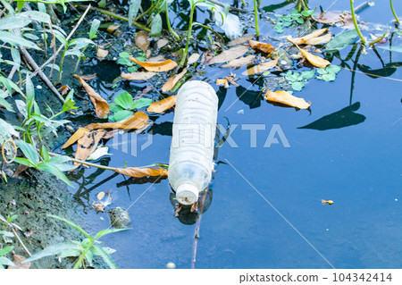 Waste from plastic bottle floating on water surface in river is a problem and water pollution in evening. Eastern of Thailand drain water into sea. In nature day light. Waste from plastic bottle floating on water surface in river is a problem and water pollution in evening. Eastern of Thailand drain water into sea. In nature day light. 104342414