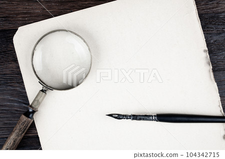Antique vintage magnifying glass with old paper and ink feather pen Antique vintage magnifying glass with old paper and ink feather pen 104342715