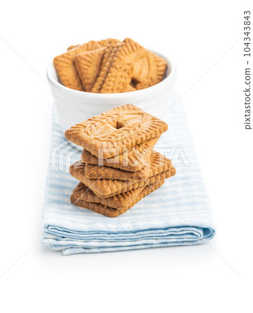 Sweet caramel biscuits. Tasty cookies on napkin isolated on white background. 104343843