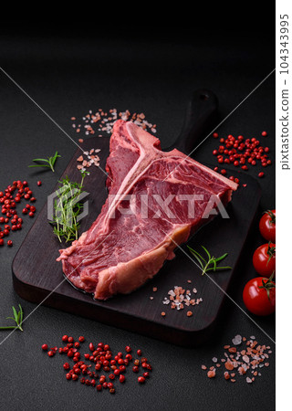 Raw juicy beef t-bone steak with salt, spices and herbs Raw juicy beef t-bone steak with salt, spices and herbs 104343995