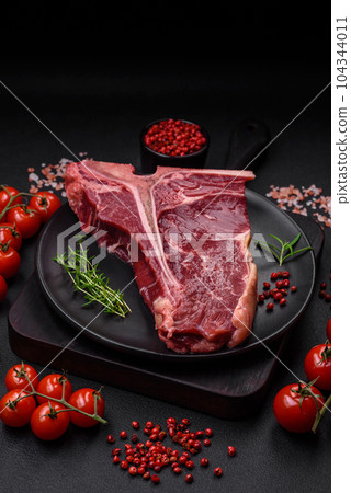 Raw juicy beef t-bone steak with salt, spices and herbs Raw juicy beef t-bone steak with salt, spices and herbs 104344011