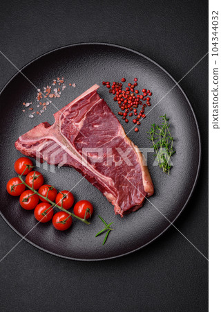 Raw juicy beef t-bone steak with salt, spices and herbs Raw juicy beef t-bone steak with salt, spices and herbs 104344032