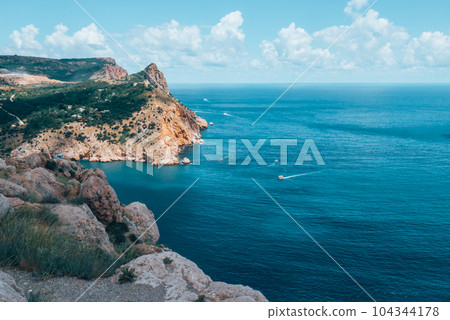 Sailboat sailing on the distance on great majestic mountains background. 104344178