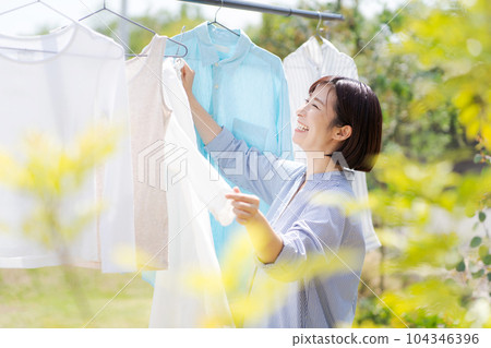 Portrait of a woman doing laundry Portrait of a woman doing laundry 104346396