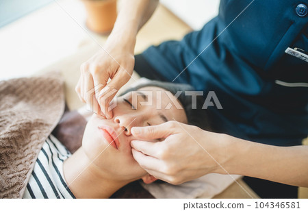 年輕女子在她的臉上被按摩 104346581