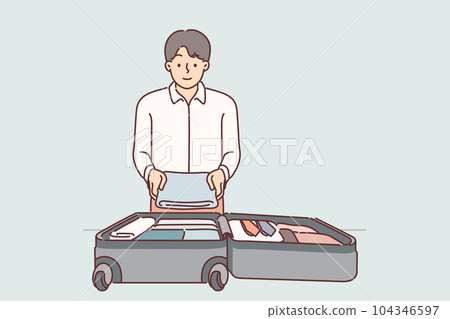 Business man puts clothes in suitcase on wheels going on official trip to sign important contract Business man puts clothes in suitcase on wheels going on official trip to sign important contract 104346597