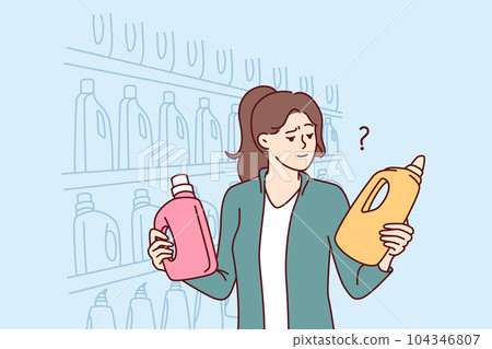 Woman holds bottles of laundry detergent or cleaning product standing near shelves in supermarket Woman holds bottles of laundry detergent or cleaning product standing near shelves in supermarket 104346807