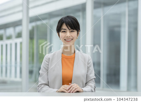 A business woman in her thirties smiling at the camera 104347238