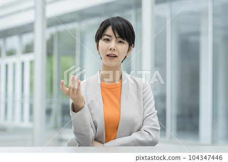 Business woman in her thirties talking to the camera 104347446
