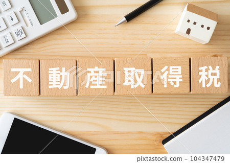 Image of real estate acquisition tax | Wooden block, calculator, smartphone, miniature house 104347479