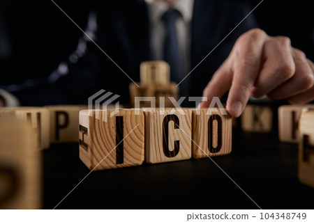 ICO symbol. Businessman hand turns wooden cubes ICO. ICO symbol. Businessman hand turns wooden cubes ICO. 104348749