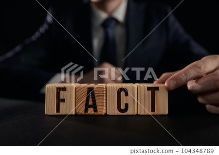 Male hand showing Fact word on wooden cube. 104348789