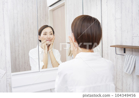 Middle-aged women doing skin care in the washroom 104349456
