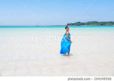 一位年輕女子在無盡的淺海中享受假期 一位年輕女子在無盡的淺海中享受假期 104349599