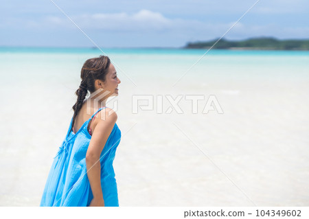 A young woman enjoying her vacation walking in the endless shallow sea A young woman enjoying her vacation walking in the endless shallow sea 104349602