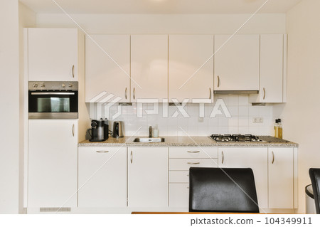 a kitchen with white cupboards and appliances on the counter top in front of the oven, microwave and dishwasher a kitchen with white cupboards and appliances on the counter top in front of the oven, microwave and dishwasher 104349911
