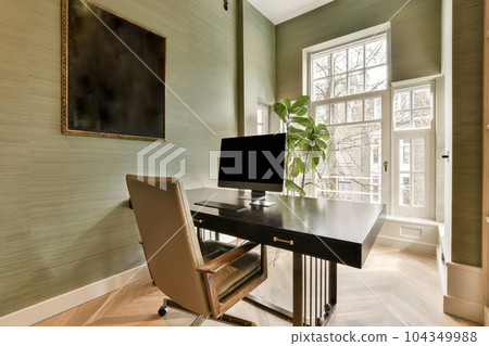 a home office with a desk and chair in front of a large painting on the wall behind it is a window 104349988