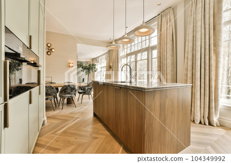 a kitchen and dining area in a house with wood flooring, white walls and large windows that look out onto the street a kitchen and dining area in a house with wood flooring, white walls and large windows that look out onto the street 104349992