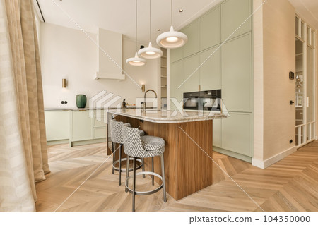 a modern kitchen with wood flooring and light green cabinets in the room is also decorated with white pendants 104350000