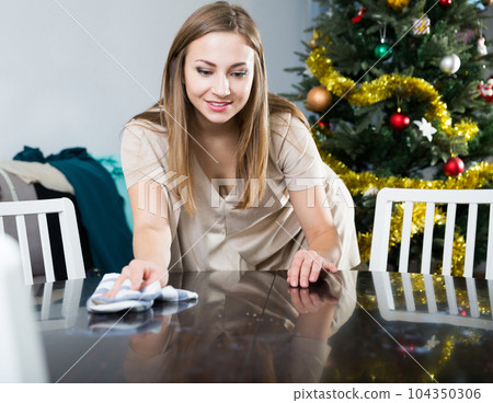 Woman cleaning table before dinner Woman cleaning table before dinner 104350306