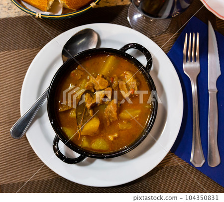 Stewed beef in sauce served with potatoes on platter 104350831