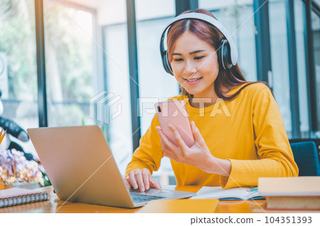 young student wearing headphones studies online, distance learning, and keeps up to date on the global coronavirus pandemic. young student wearing headphones studies online, distance learning, and keeps up to date on the global coronavirus pandemic. 104351393