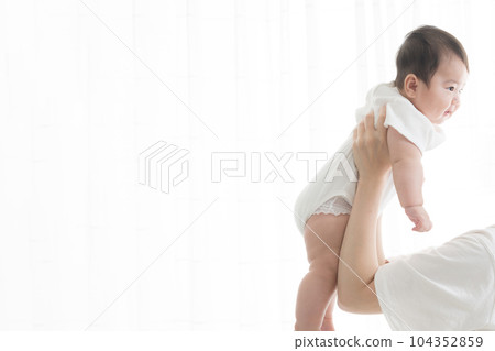 Baby doing high high in the backlight with copy space 104352859