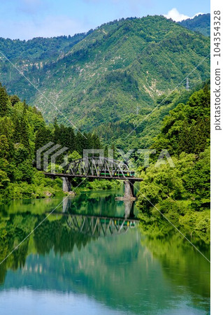 Tadami Line Kiha E120 train crossing the No. 4 Tadami River Bridge in spring (Kanayama Town, Fukushima Prefecture, late May morning) Tadami Line Kiha E120 train crossing the No. 4 Tadami River Bridge in spring (Kanayama Town, Fukushima Prefecture, late May morning) 104354328