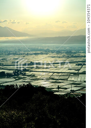 The Aizu Basin shining in the backlight seen from Futanuma Forest Park (Aizumisato Town, Fukushima Prefecture, early morning in early June) 104354371