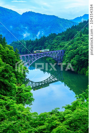 Tadami Line Train crossing the Daiichi Tadami River Bridge in early summer (Mishima Town, Fukushima Prefecture, early morning in mid-June) 104354384