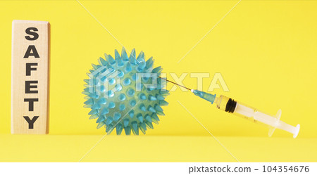 Security Tex on a wooden block, next to an injection and a virus on a yellow background 104354676