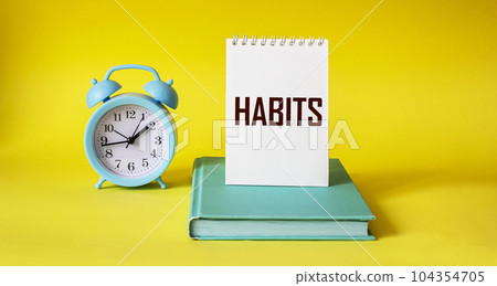 Habits word written on notepad and yellow background 104354705