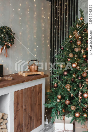 Home New Year's interior. Christmas tree with gifts, decorated with garlands in the kitchen. Cozy atmosphere of a home holiday, loft design of the room, Scandinavian style. Home New Year's interior. Christmas tree with gifts, decorated with garlands in the kitchen. Cozy atmosphere of a home holiday, loft design of the room, Scandinavian style. 104354832