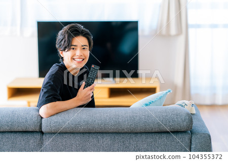 young man watching tv 104355372