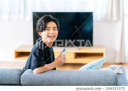 young man watching tv 104355373
