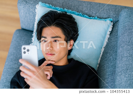 操作智能手機的一個年輕人 104355413
