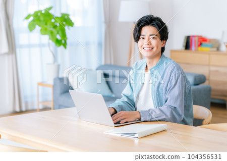 一個年輕人在客廳裡做遠程辦公 104356531