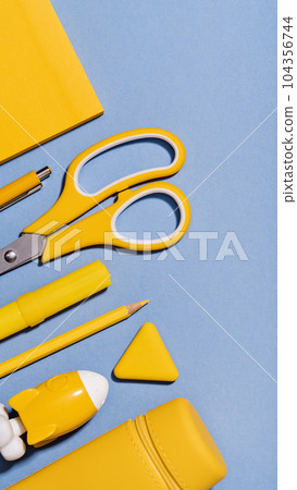 Assorted office and school yellow stationery on lilac blue. copy space for back to school or education craft office work concept. Bright Yellow rocket. Achievement and success. Top view 104356744